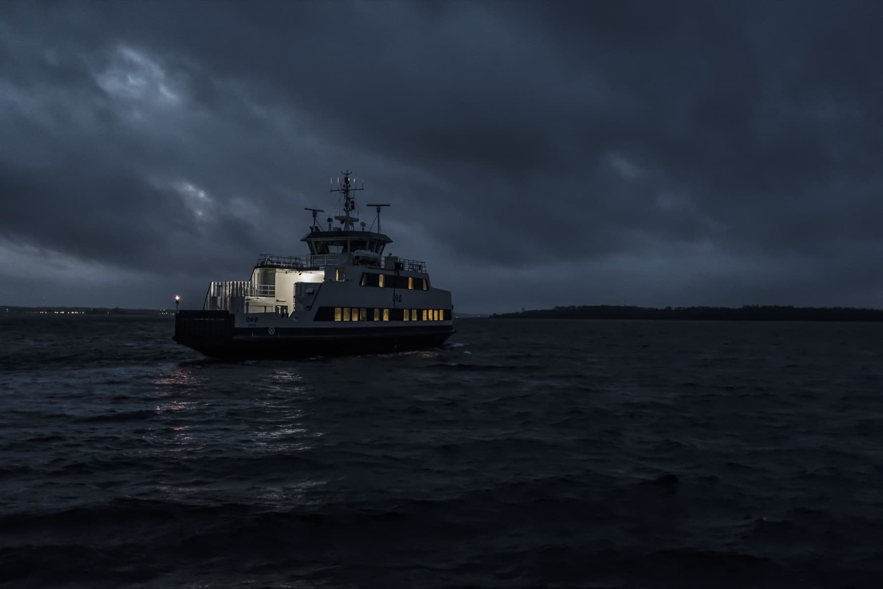 Passenger ferry moving through dark water at night