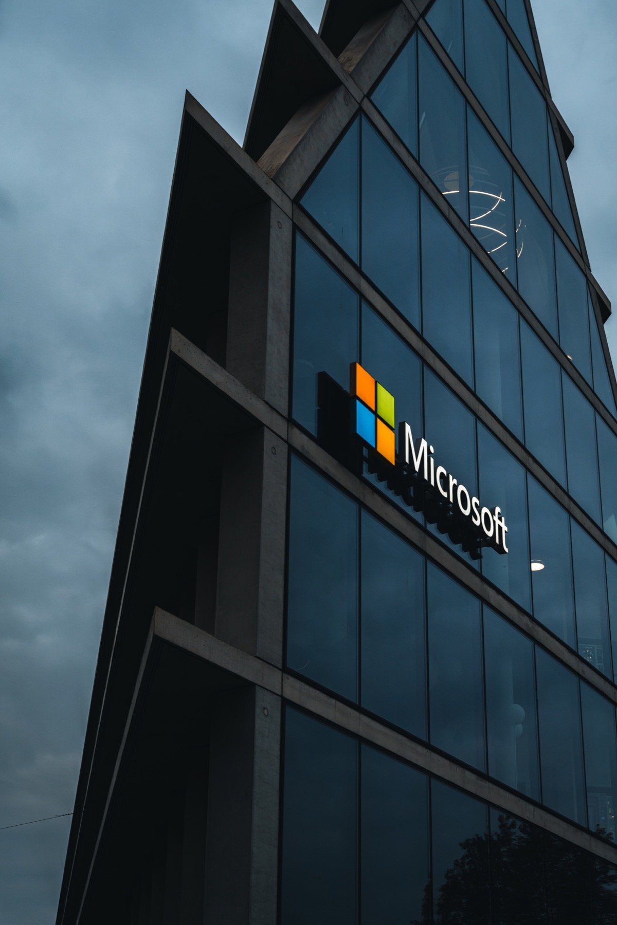 Modern glass Microsoft building facade with the Microsoft logo against an overcast sky