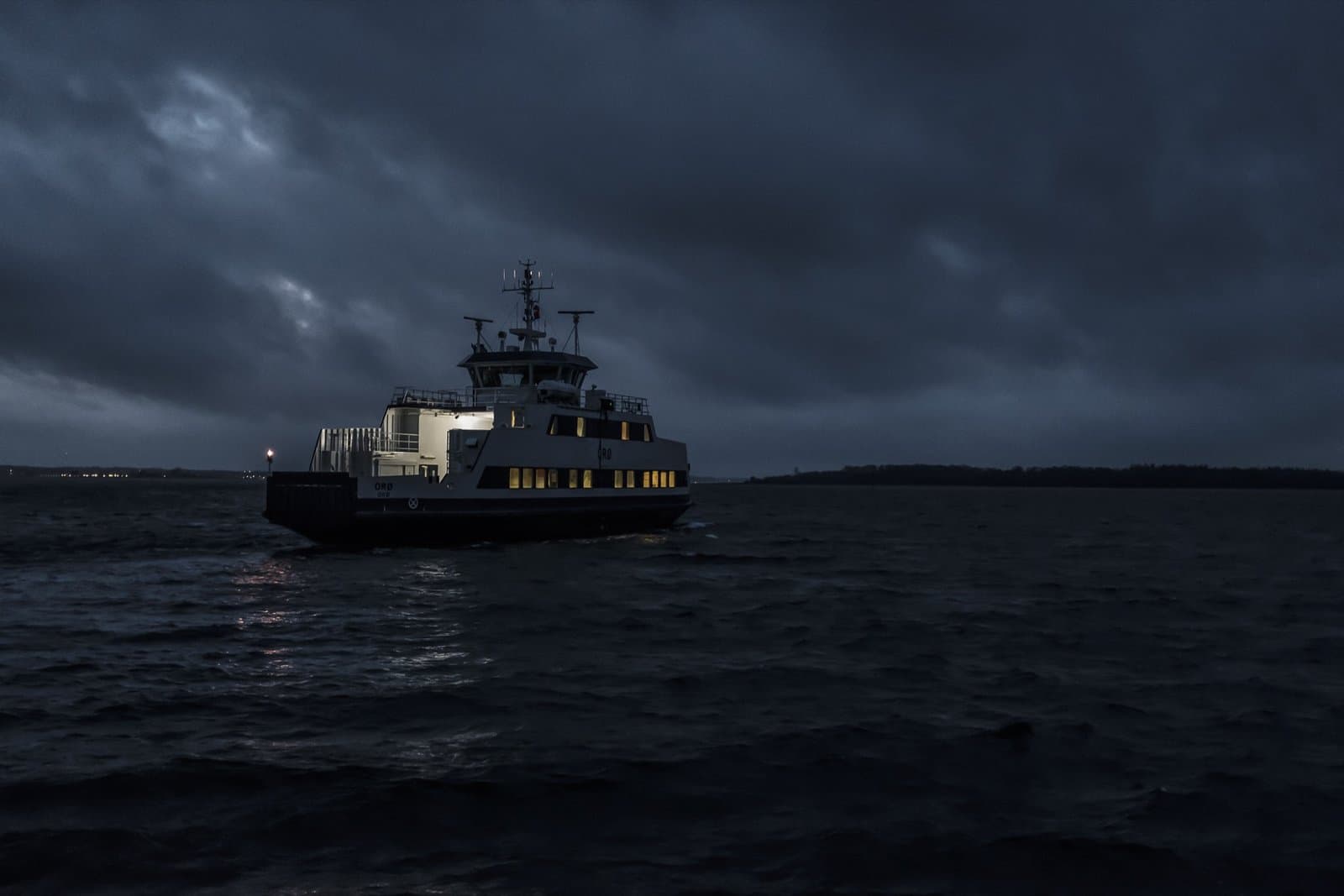 Passenger ferry moving through dark water at night